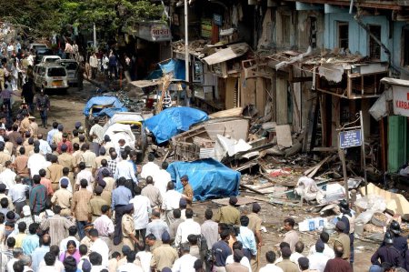 Photo for Policemen inspecting site of bomb blast also large number of people gathered to look at the site at Zaveri Bazaar in busy Kalbadevi area; Bombay Mumbai, Maharashtra, India August 26th 2003 - Royalty Free Image