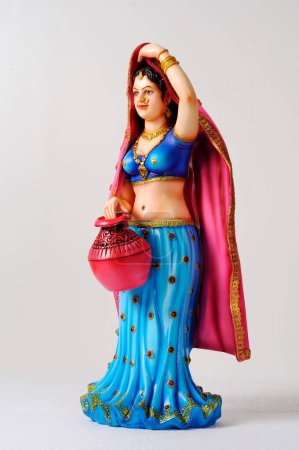 Figurine en argile, statue de la jeune fille rajasthani avec sari pallu sur la tête et tenant pot coloré