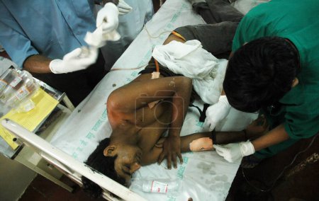 Photo for Injured person gets medical attention at J J Hospital after terror attack by Deccan Mujahideen terrorists in Bombay Mumbai, Maharashtra, India 27 November 2008 - Royalty Free Image