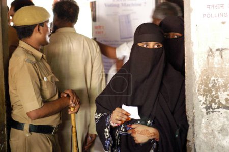 Foto de Mujer musulmana esperando su turno para emitir su voto durante las elecciones indias de Loksabha de 2004 en la cabina electoral de Shivaji Nagar, Govandi, Bombay Maharashtra, India - Imagen libre de derechos