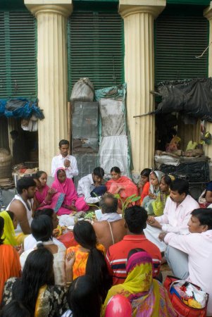 Photo for Brahmin reading scripture and performing Satya Narayan Pooja at Babu Ghat, Kolkata, India - Royalty Free Image