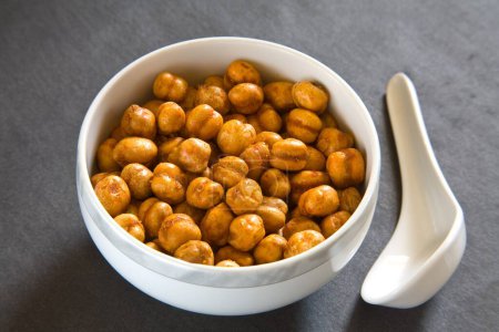 Photo for Indian breakfast fry chickpeas chana masala served in bowl with spoon on black background 12-May-2010 - Royalty Free Image