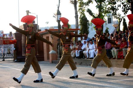 Téléchargez les photos : Soldat des forces de sécurité frontalières indiennes faisant un défilé avant de commencer la cérémonie de changement de garde à la frontière de Wagah, Amritsar, Punjab, Inde - en image libre de droit