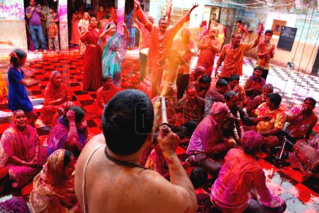 Téléchargez les photos : Prêtre jouant Holi avec les dévots dans le temple shyamji gang, Jodhpur, Rajasthan, Inde - en image libre de droit