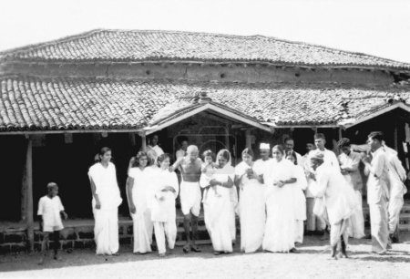 Foto de Mahatma Gandhi, caminando con Uma Om Agarwal 2º de Mahatma Gandhi y otros en el Ashram Sevagram, 1940 - Imagen libre de derechos