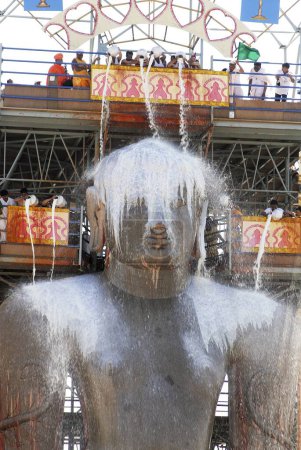 Photo for Jain Devotees pouring milk on the head of 58.8 feet monolithic Statue of jain saint Gomateshwara (Lord Bahubali) in Mahamastakabhisheka (head anointing ceremony) on the Vindhyagiri hill, Shravanbelagola, Karnataka, India - Royalty Free Image