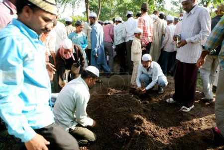 Téléchargez les photos : Des personnes enterrant des membres de leur famille morts dans un puissant attentat à la bombe le 29 septembre 2008 à Malegaon, Maharashtra, Inde - en image libre de droit