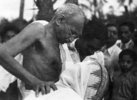 Téléchargez les photos : Mahatma Gandhi, soutenu par deux personnes Juhu Beach, Mumbai, mai 1944, Inde - en image libre de droit