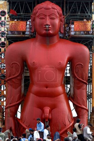 Photo for 58.8 feet monolithic full length statue of jain saint Gomateshwara lord Bahubali covered in Vermillion water in Mahamastakabhisheka head anointing ceremony, Sravanabelagola, Karnataka, India - Royalty Free Image