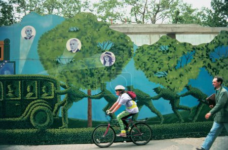 Téléchargez les photos : Cycliste excès de vitesse passé mur peint avec tableau comique, Singapour - en image libre de droit