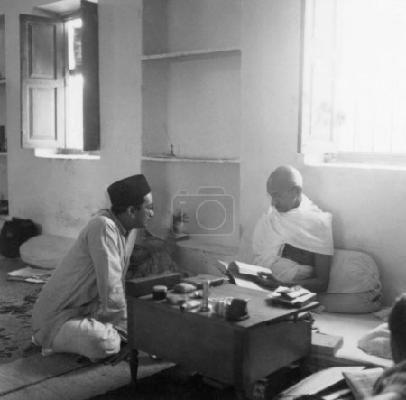 Photo for Mahatma Gandhi reading and talking to BK Birla at Bhangi Colony in Delhi, 1946, India - Royalty Free Image