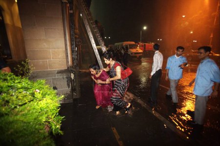 Photo for Guests and Taj personnel evacuated from Taj Mahal hotel during terrorist attack by Deccan Mujahedeen , Bombay Mumbai , Maharashtra , India 26_November_2008 - Royalty Free Image