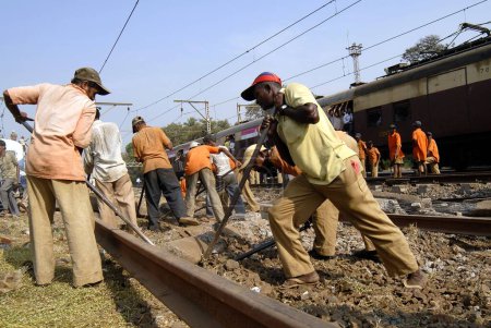 Foto de Trabajadores ferroviarios reparan vías ferroviarias dañadas después de descarriladas locales; Bombay Mumbai; Maharashtra; India - Imagen libre de derechos