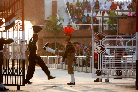Téléchargez les photos : Soldat des forces de sécurité frontalières indiennes et homologue pakistanais faisant un défilé avant de commencer la cérémonie de changement de garde à la frontière de Wagah ; Amritsar, Punjab, Inde - en image libre de droit