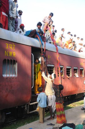 Téléchargez les photos : Personnes grimpant sur le toit du train pour un voyage risqué, gare de Marwar, Rajasthan, Inde - en image libre de droit