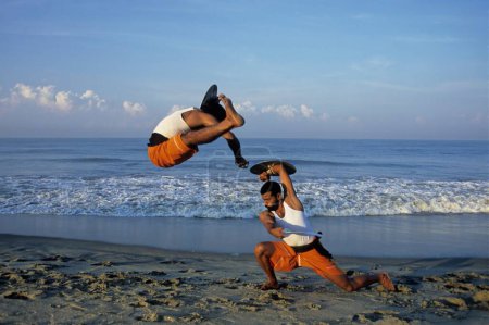 Foto de Dos hombres realizando Kalaripayattu en las playas de Kerala de la India - Imagen libre de derechos