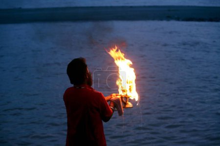 Téléchargez les photos : Prêtres faisant les prières sacrées du soir de la rivière Ganga sur les rives de la rivière à Rishikesh dans l'Uttaranchal, Inde - en image libre de droit