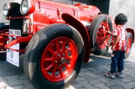 Téléchargez les photos : Un jeune admirateur de voiture ; Rassemblement de voitures anciennes à Kala Ghoda ; Bombay Mumbai ; Maharashtra ; Inde - en image libre de droit