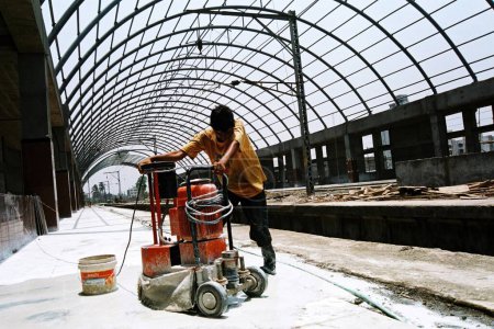 Téléchargez les photos : Travailleur polissage de carreaux de marbre pendant la construction de la gare de Kharghar ; banlieue de Bombay maintenant Navi Mumbai ; Maharashtra ; Inde - en image libre de droit