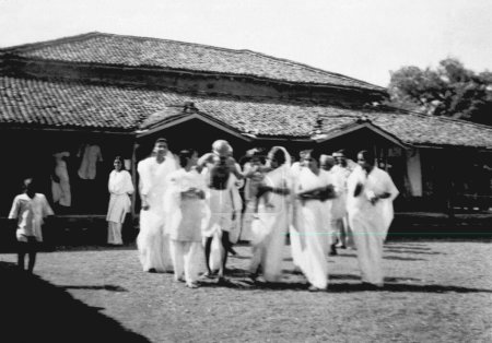 Foto de Mahatma Gandhi caminando con otros en el Ashram Sevagram, 1941 - Imagen libre de derechos