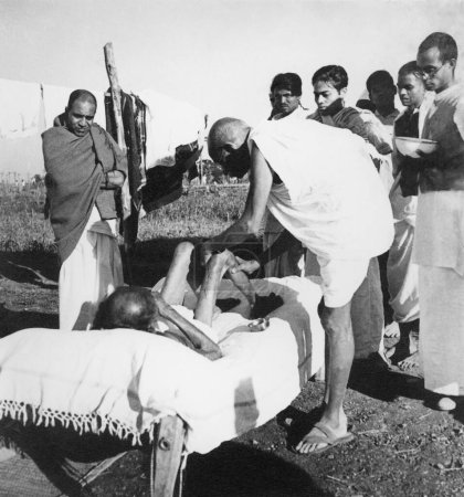 Téléchargez les photos : Mahatma Gandhi, infirmière lépreuse Parchure Shastri à l'ashram de Sevagram, 1940 - en image libre de droit