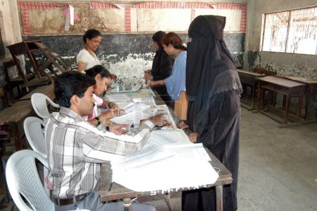 Foto de Mujer musulmana siendo identificada antes de emitir su voto durante 2004, elecciones indias de Loksabha en la cabina de votación en Shivaji Nagar, Govandi, Bombay Mumbai, Maharashtra, India - Imagen libre de derechos
