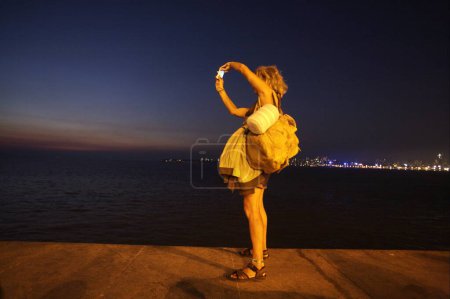 Photo for Foreign tourist taking pictures of queen necklace standing at other end of Marine drive in Bombay Mumbai , Maharashtra , India - Royalty Free Image