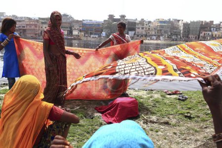 Foto de Mujer Drying saree on Yamuna river at Uttar Pradesh India - Imagen libre de derechos