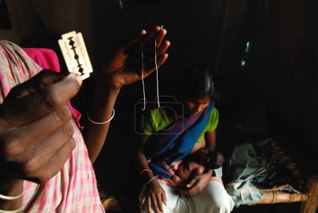 Téléchargez les photos : Sage-femme des tribus Ho montrant le fil et le rasoir, Chakradharpur, Jharkhand, Inde - en image libre de droit