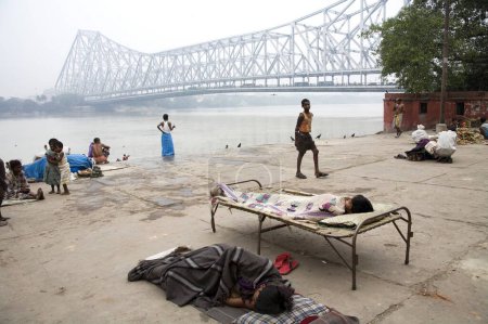 Photo for Activities on Babu ghat ; Howrah bridge over Hooghly river in background ; Calcutta now Kolkata ; West Bengal ; India - Royalty Free Image