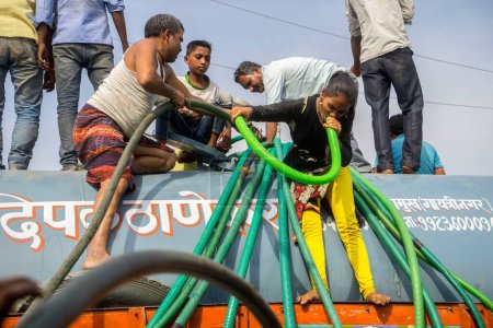 Foto de Personas llenando agua en tambores de plástico de cisterna de agua, Bhiwandi, Maharashtra, India - Imagen libre de derechos