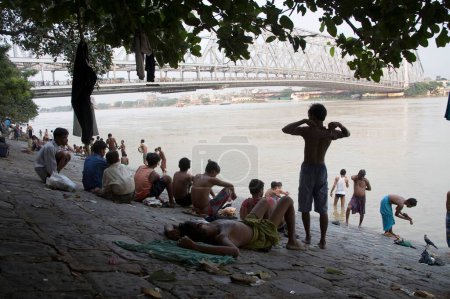 Téléchargez les photos : Activités humaines sur la rive de la rivière HooGrosso modo ; pont Howrah ou Rabindra Setu ; Calcutta Kolkata ; Bengale occidental ; Inde - en image libre de droit