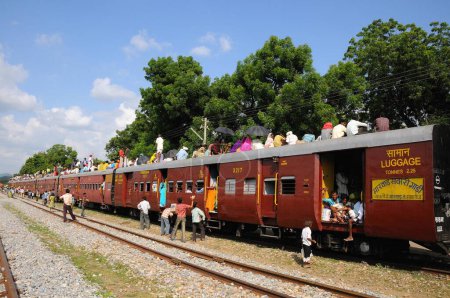 Téléchargez les photos : Personnes grimpant sur le toit du train pour les voyages risqués ; Gare de Marwar ; Rajasthan ; Inde - en image libre de droit