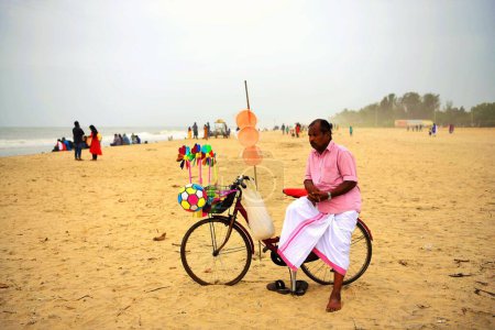 Foto de Vendedor de molinete de plástico colorido en bicicleta, Alappuzha Beach, Alleppey, Kerala, India, Asia - Imagen libre de derechos