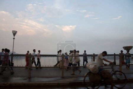 Foto de Peatonal caminando en el puente Howrah ahora Rabindra Setu estructura de acero increíble hazaña de ingeniería a través del río hooghly; Calcuta ahora Calcuta; Bengala Occidental; India - Imagen libre de derechos