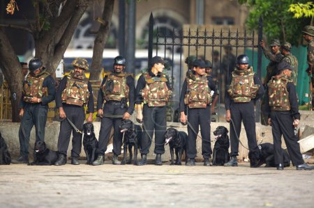 Téléchargez les photos : Gardiens de la sécurité nationale NSG commandes avec des chiens devant l'hôtel Taj Mahal après avoir tué des terroristes. Bombay Mumbai. Maharashtra. Inde - en image libre de droit