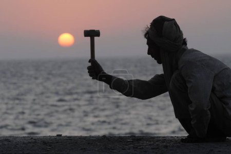 Téléchargez les photos : Un ouvrier de la construction travaille pendant le coucher du soleil à Marine Drive ; Bombay maintenant Mumbai ; Maharashtra ; Inde - en image libre de droit