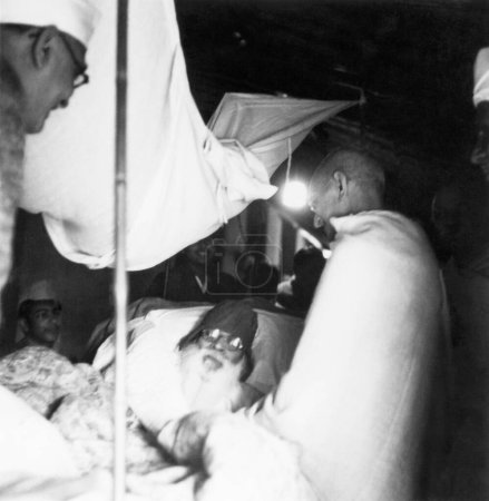 Foto de Mahatma Gandhi visitando al constructor del templo de Bharat Mata, Shivprasad Gupta, que estaba enfermo, en Varanasi, 1941, Mahadev Desai, India - Imagen libre de derechos
