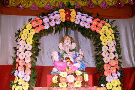 Foto de Ídolo del Señor Ganesh mantenido en marco alegremente decorado de flores coloridas elefante cabeza dios; Ganapati año del festival 2008 en Pune; Maharashtra; India - Imagen libre de derechos