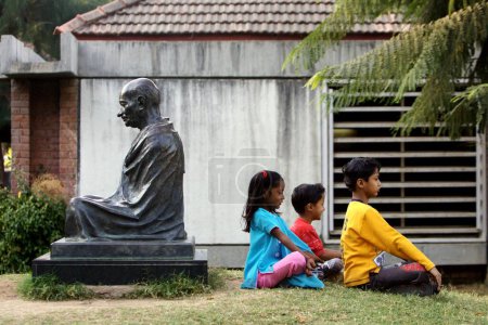 Photo for Children playing near the Statue of Mahatma Gandhi at the Sabarmati Ashram also Known as Gandhi Ashram located on Western banks of Sabarmati River ; Ahmedabad ; Gujarat ; India - Royalty Free Image