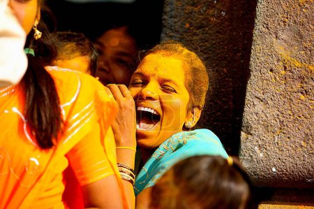 Foto de Mujeres devotas que se aplican mutuamente la cúrcuma durante las celebraciones durante el dasshera en el templo jejuri, pune, Maharashtra, India - Imagen libre de derechos