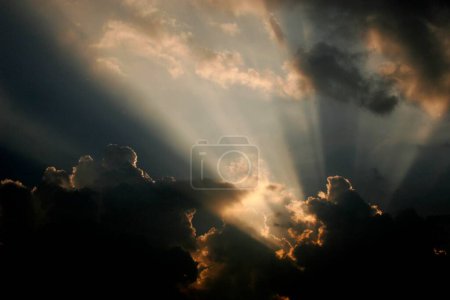 Sunrays piercing through clouds during sunrise ; Pune ; Maharashtra ; India
