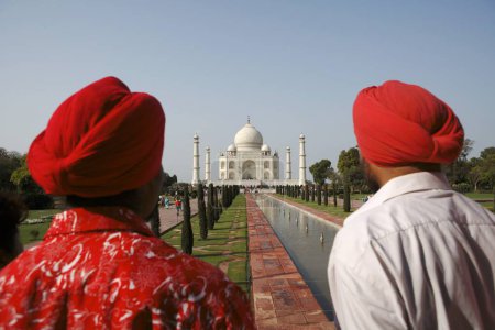 Téléchargez les photos : Deux frères sikhs regardant au Taj Mahal Septième merveilles du monde sur la rive sud du fleuve Yamuna, Agra, Uttar Pradesh, Inde Patrimoine mondial de l'UNESCO - en image libre de droit