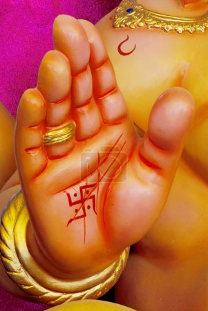 Téléchargez les photos : Idole du seigneur Ganesh Ganpati dieu tête d'éléphant ou Vinayak Gajanan swastika peint à la main, Inde - en image libre de droit