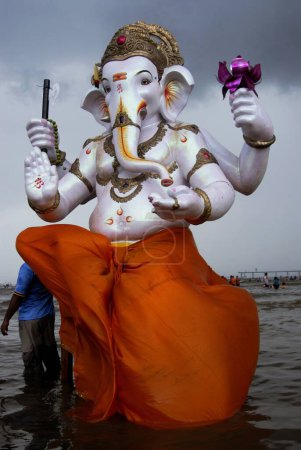 Foto de Ganesh Ganpati festival; personas que llevan el ídolo del Señor Ganesh para la inmersión en la playa de Dadar; Mumbai Bombay; Maharashtra; India - Imagen libre de derechos