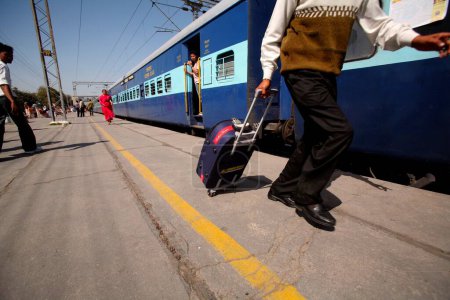 Téléchargez les photos : Passager avec sac trolley à la gare en Inde - en image libre de droit
