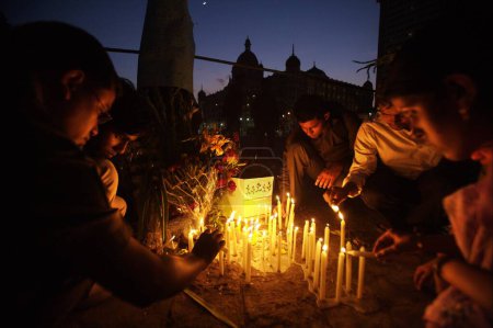 Foto de Personas encendiendo velas en Gateway, de, India y rindiendo homenaje a las víctimas del ataque terrorista por Deccan Mujahedeen el 26 de noviembre de 2008 en Bombay Mumbai, Maharashtra, India - Imagen libre de derechos