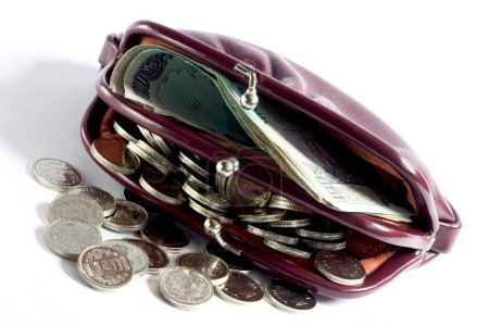 Ein Entsperren Damenhandtasche oder Brieftasche ausgesetzt Menge indischer Währung hundert Rupien und fünf Rupien Münze auf weißem Hintergrund