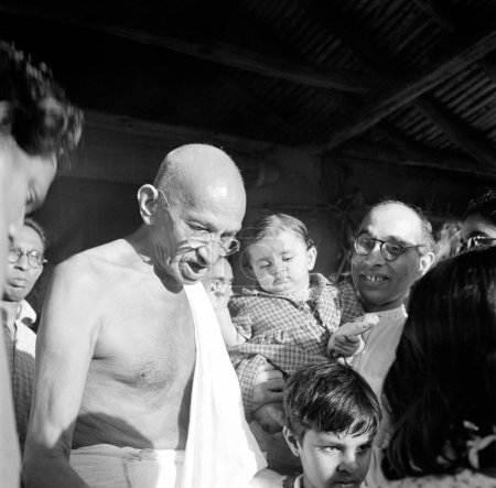 Téléchargez les photos : Mahatma Gandhi et Pyarelal Nayar, qui porte sa nièce Nandini à l'ashram de Sevagram, août 1944 - en image libre de droit