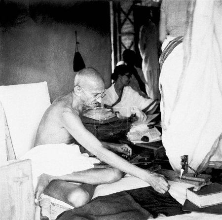 Téléchargez les photos : Mahatma Gandhi tournant dans sa cabane à l'Ashram de Sevagram, le 4 août 1940, Rajkumari Amrit Kaur - en image libre de droit